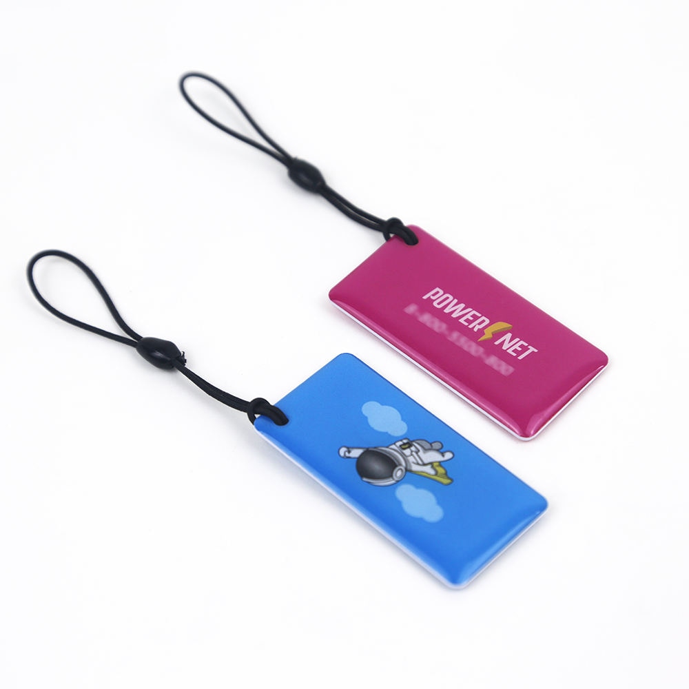 ภาพที่ 6: ภาพนี้แสดงพวงกุญแจ RFID พิมพ์ลายสำหรับทางเข้า ลงเวลา และสมาชิก โดยเน้นรูปทรง พื้นผิว และรายละเอียดผลิตภัณฑ์ตามภาพ สำหรับงานทางการแพทย์และการระบุตัวผู้ป่วย.