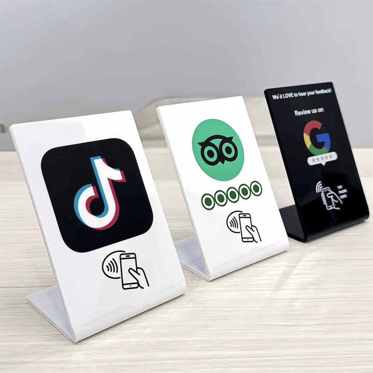 ภาพที่ 5: ภาพนี้แสดงป้ายตั้งโต๊ะ NFC หลายวัสดุสำหรับรีวิว เมนู และชำระเงิน โดยเน้นแบบโปร่งใส เรซินหรืออะคริลิก การทำงานรวดเร็ว โครงสร้างเสาอากาศและชิปภายใน และการเชื่อมต่อแบบไร้สัมผัสหรือไร้สาย ระหว่างการใช้งานจริง สำหรับการมีส่วนร่วมของลูกค้าและการจัดการชื่อเสียงธุรกิจ.