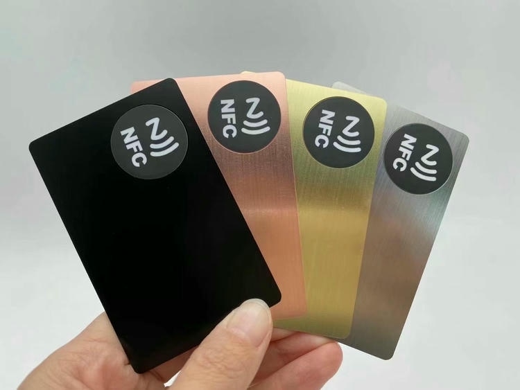 ภาพที่ 5: ภาพนี้แสดงนามบัตรโลหะพรีเมียมขายส่งพร้อมสลักและ QR NFC โดยเน้นสีดำ สีทอง สีเงิน โลหะ โครงสร้างแข็งแรงทนทาน และการเชื่อมต่อแบบไร้สัมผัสหรือไร้สาย สำหรับการมีส่วนร่วมของลูกค้าและการจัดการชื่อเสียงธุรกิจ.