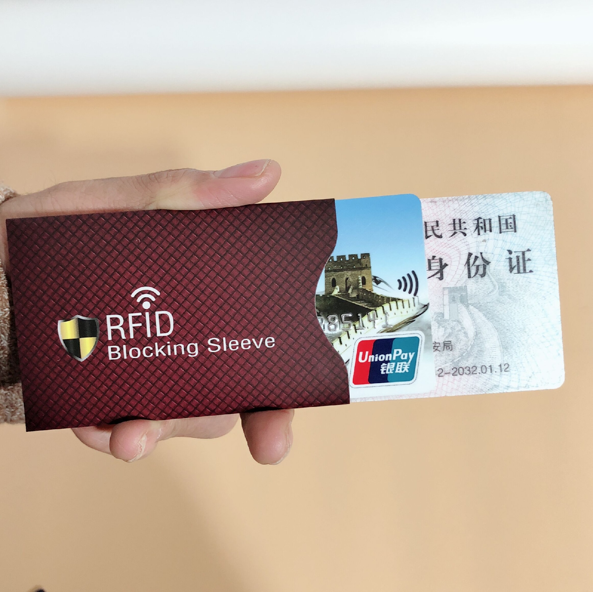 ซองบล็อก RFID สีน้ำตาลแดงผิว textured ถูกแสดงขณะที่บัตรประจำตัวเลื่อนออกมาเพื่อสาธิตการจัดเก็บบัตรป้องกันการโจรกรรมในชีวิตประจำวัน