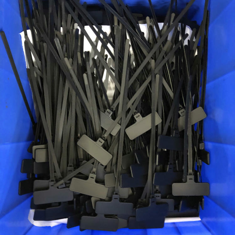 ภาพถ่ายกล่องแสดง RFID zip tie แท็ก รุ่น Z31079-1 สีดำและสีเทาวางซ้อนกันพร้อมสายรัดยาวที่พร้อมสำหรับการประกอบหรือการพิมพ์
