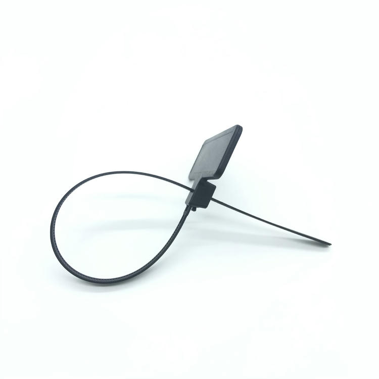 ภาพถ่ายมุมมองด้านข้างบนโต๊ะแสดง RFID zip tie แท็ก รุ่น Z31079-1 สีดำที่ทำเป็นห่วงโดยหันหน้าป้ายขึ้นด้านบนเพื่อแสดงความหนาและรูปแบบการปิดผนึก