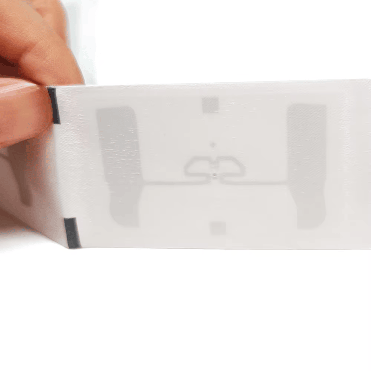 7) ภาพนี้แสดงแท็กผ้าทอ UHF RFID ซักได้สำหรับติดตามเสื้อผ้า โดยเน้นสีขาว สิ่งทอ และโครงสร้างเสาอากาศและชิปภายใน ในลักษณะติดตั้งกับชิ้นงาน.