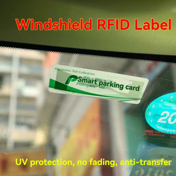ภาพระยะใกล้บนกระจกหน้ารถยนต์แสดงบัตรจอดรถอัจฉริยะสีเขียวที่เป็นฉลาก RFID UHF สาธิตการป้องกันรังสี UV และความต้านทานการถ่ายโอน