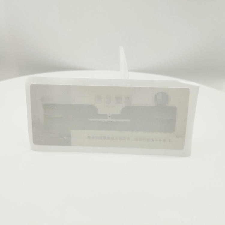 มุมมองด้านหน้าของแท็ก RFID กระจกหน้ารถยนต์ UHF บนฉากสีขาว เน้นหน้าต่างอินเลย์และรูปทรงขอบสำหรับการติดตั้งด้านในกระจก
