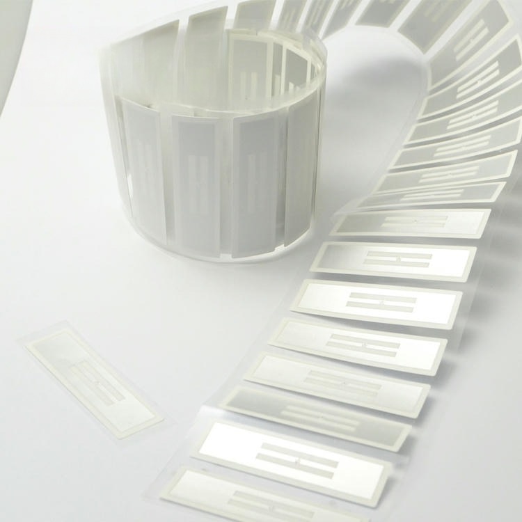 ม้วนและแถบที่คลี่ออกของฉลาก RFID ที่ต้านทานของเหลวถูกจัดเรียงเพื่อนำเสนอรูปแบบผลิตภัณฑ์จากหลายมุม