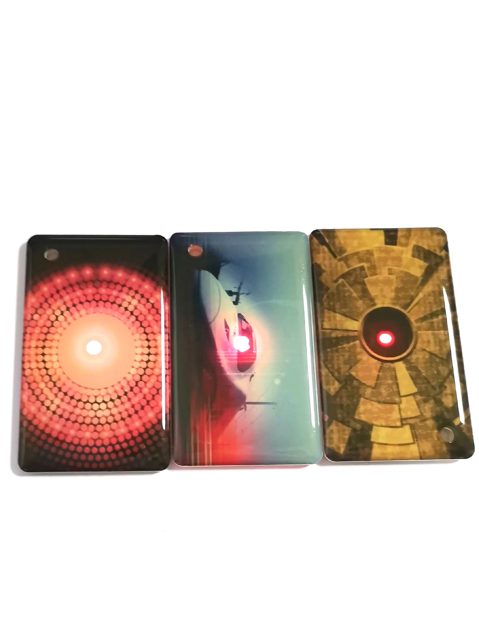 บัตร NFC พร้อมไฟ LED แสดงเป็นด้านหน้าบัตรสามใบที่มีลวดลายหน้าต่าง LED ต่างกันเพื่อเปรียบเทียบการมองเห็นระหว่างการแตะ