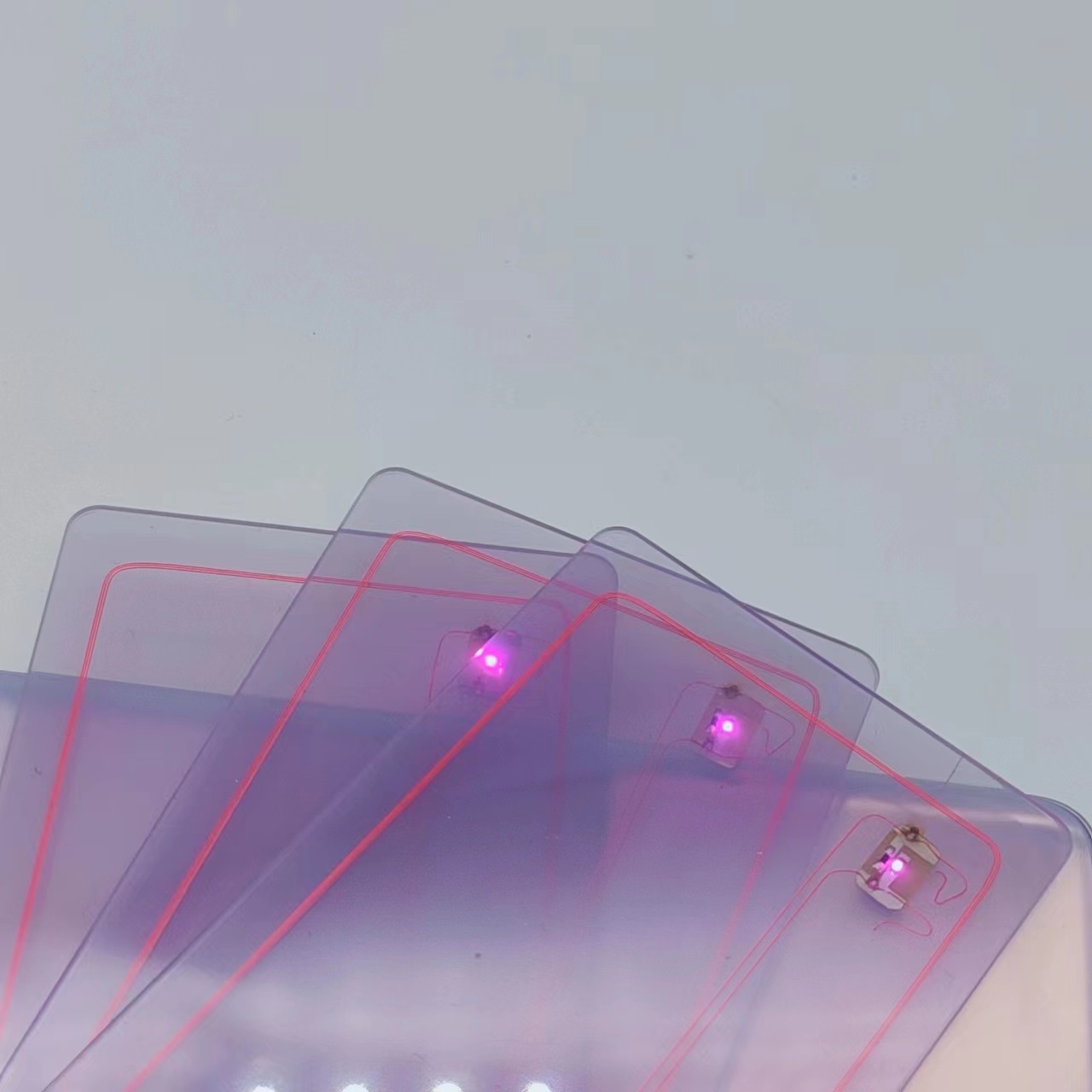 ภาพมาโครของบัตร NFC พร้อมไฟ LED แสดงไฟ LED สีม่วงที่มุมบัตรเพื่อการตอบสนองแบบไม่สัมผัสที่มองเห็นได้