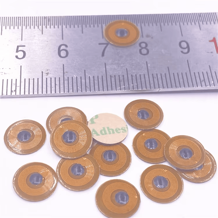 6) ภาพนี้แสดงไมโครแท็ก FPC NFC ขนาด 10mm สำหรับทรัพย์สินโลหะ FPC10-1 โดยเน้นโลหะ ขนาดกะทัดรัด ชั้นกาวสำหรับยึดติด และสัดส่วนและขนาดของผลิตภัณฑ์.