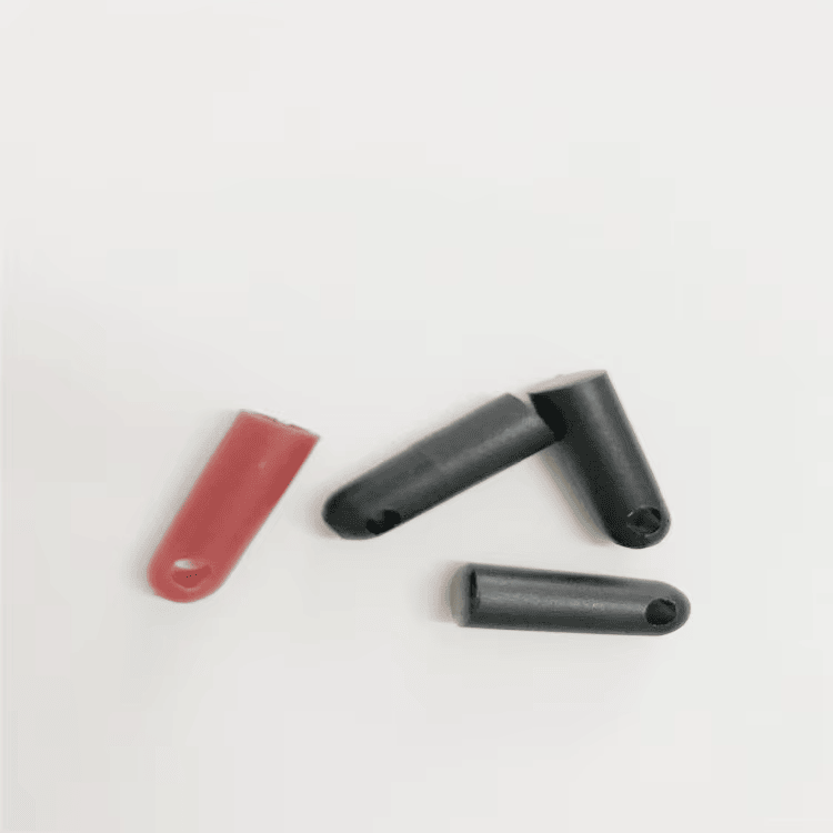 แท็ก RFID บุลเล็ตทูบรุ่น SV-005 สามชิ้นและตัวอย่างสีแดงหนึ่งชิ้นถูกจัดเรียงเพื่อแสดงตำแหน่งรูสำหรับผูกกับกิ่งไม้