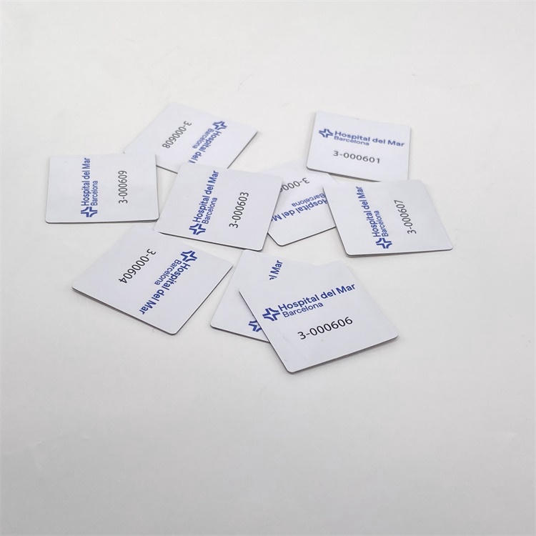 ภาพ RFID แท็ก ชนิด PVC สำหรับติดบนโลหะ แบบสี่เหลี่ยมหลายชิ้นวางเรียงบนพื้นหลังสีขาว แสดงโลโก้ที่พิมพ์และเครื่องหมายหมายเลขซีเรียลบนผิวหน้าป้ายสำเร็จรูป