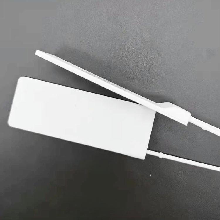 ภาพเปรียบเทียบความหนาแสดงแท็กห้อยเสื้อผ้า RFID สีขาวจากด้านข้าง ให้เห็นตัวแท็กที่บางเฉียบและจุดเชื่อมต่อห่วง