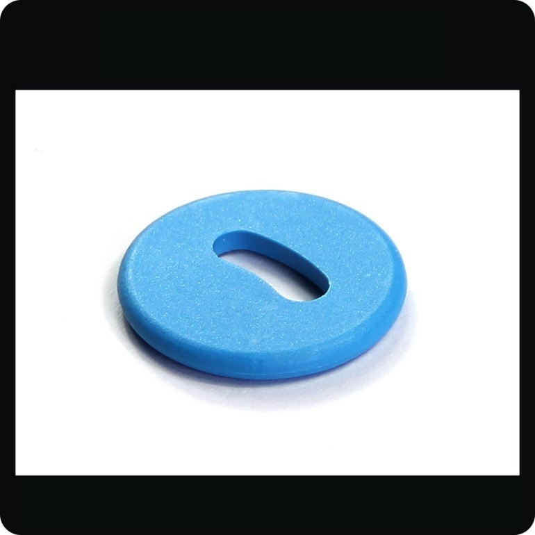แท็ก RFID PPS สีน้ำเงินชิ้นเดียวรุ่น PPSD26-1 พร้อมรูจันทร์เสี้ยวถูกถ่ายภาพระยะใกล้เพื่อแสดงตัวเรือน PPS ที่เรียบเนียนสำหรับการเย็บ