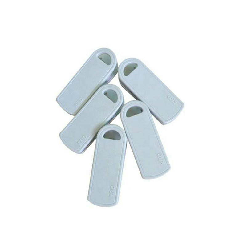 ภาพนี้แสดง SV-014 RFID clip แท็ก สีขาวห้าอันจัดกลุ่ม together เพื่อเน้นการออกแบบเปลือกนอกที่สม่ำเสมอ