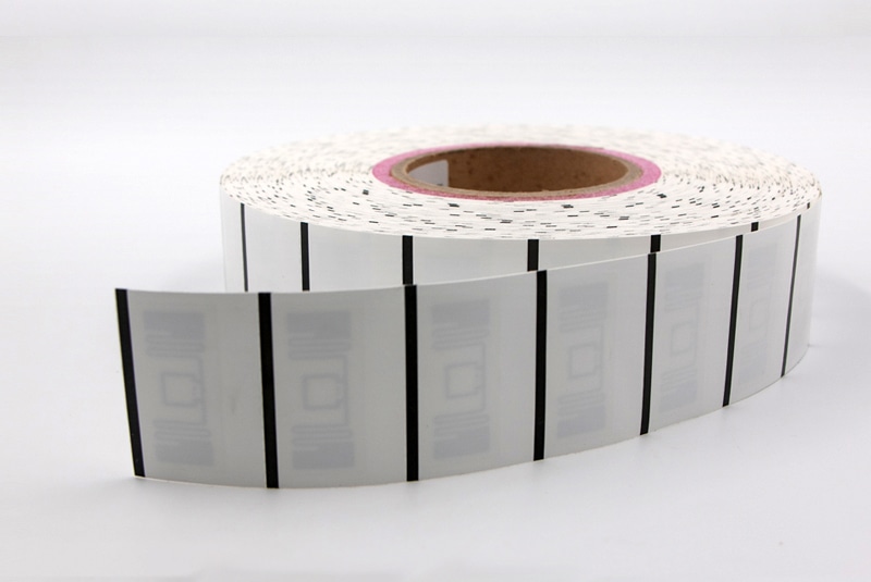 ภาพถ่ายผลิตภัณฑ์ระยะใกล้แสดงม้วนแท็กเสื้อผ้า RFID สีขาวรุ่น SV5035-1 ที่มีส่วนป้ายซ้ำๆ สำหรับการจัดการสินค้าคงคลังเครื่องแต่งกาย