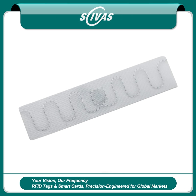 ภาพที่ 1: ภาพนี้แสดงแท็ก RFID สำหรับติดตามผ้าลินินและสิ่งทอโรงแรม UV T7015-1 โดยเน้นสีขาว และรูปทรงบาง.