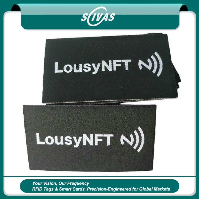 1) ภาพนี้แสดงแท็ก NFC ผ้าทอสั่งทำสำหรับเสื้อผ้า กระเป๋าและรองเท้า โดยเน้นสิ่งทอ คุณสมบัติด้านความปลอดภัยและป้องกันการแกะย้าย และความทนทานต่อการซัก สารเคมี และการฆ่าเชื้อ สำหรับการติดตามผ้าและเสื้อผ้า.